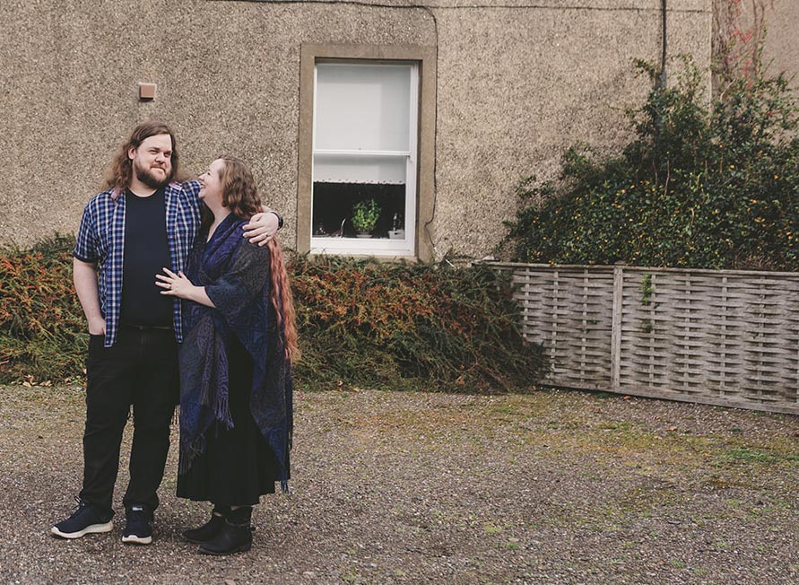 A photo of Steve and Elizabeth Ross standing outside in front of a building.